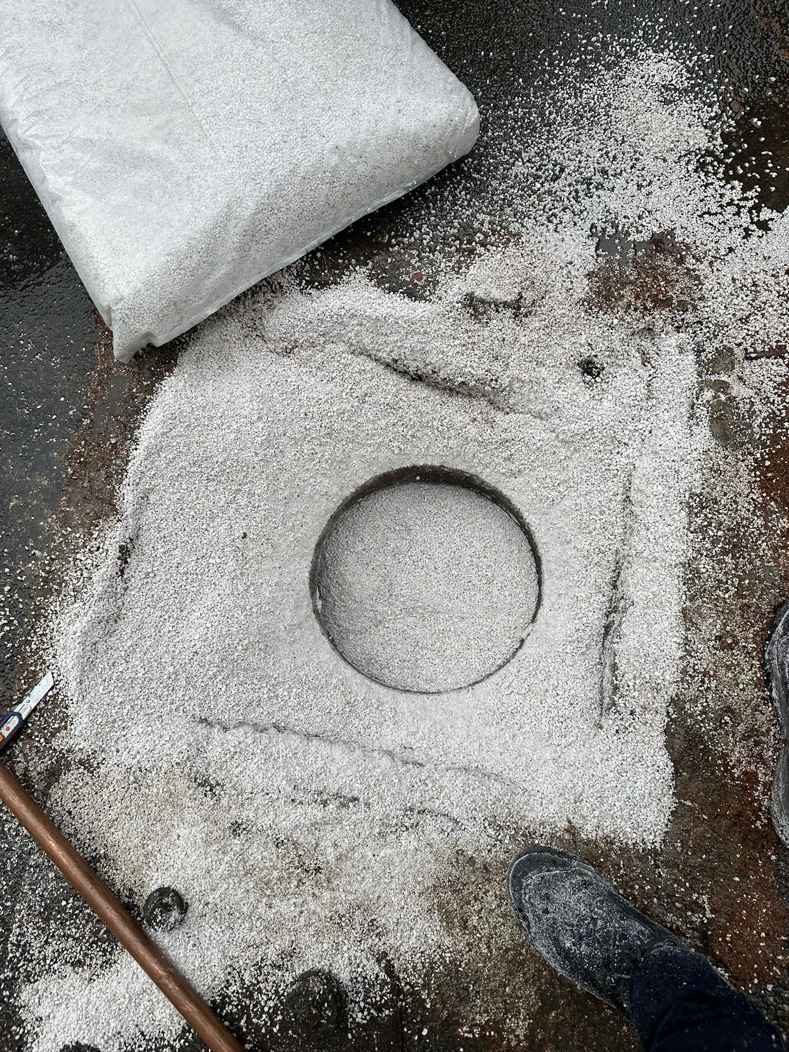 Comblement mineral leger visible autour d'une ouverture de cuve enterree