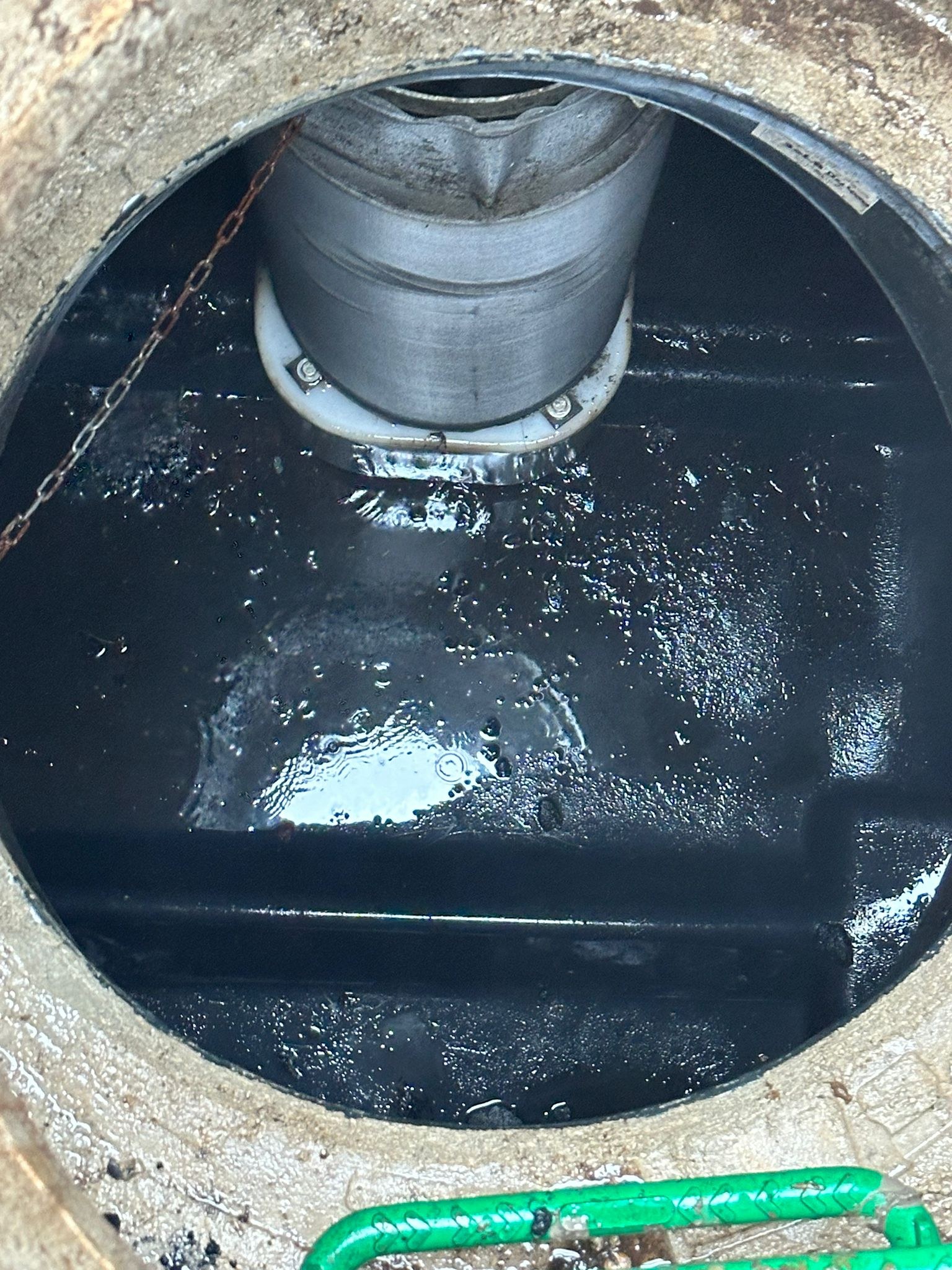 Vue intérieure d'un ouvrage cylindrique noir visible par trou d'homme ouvert