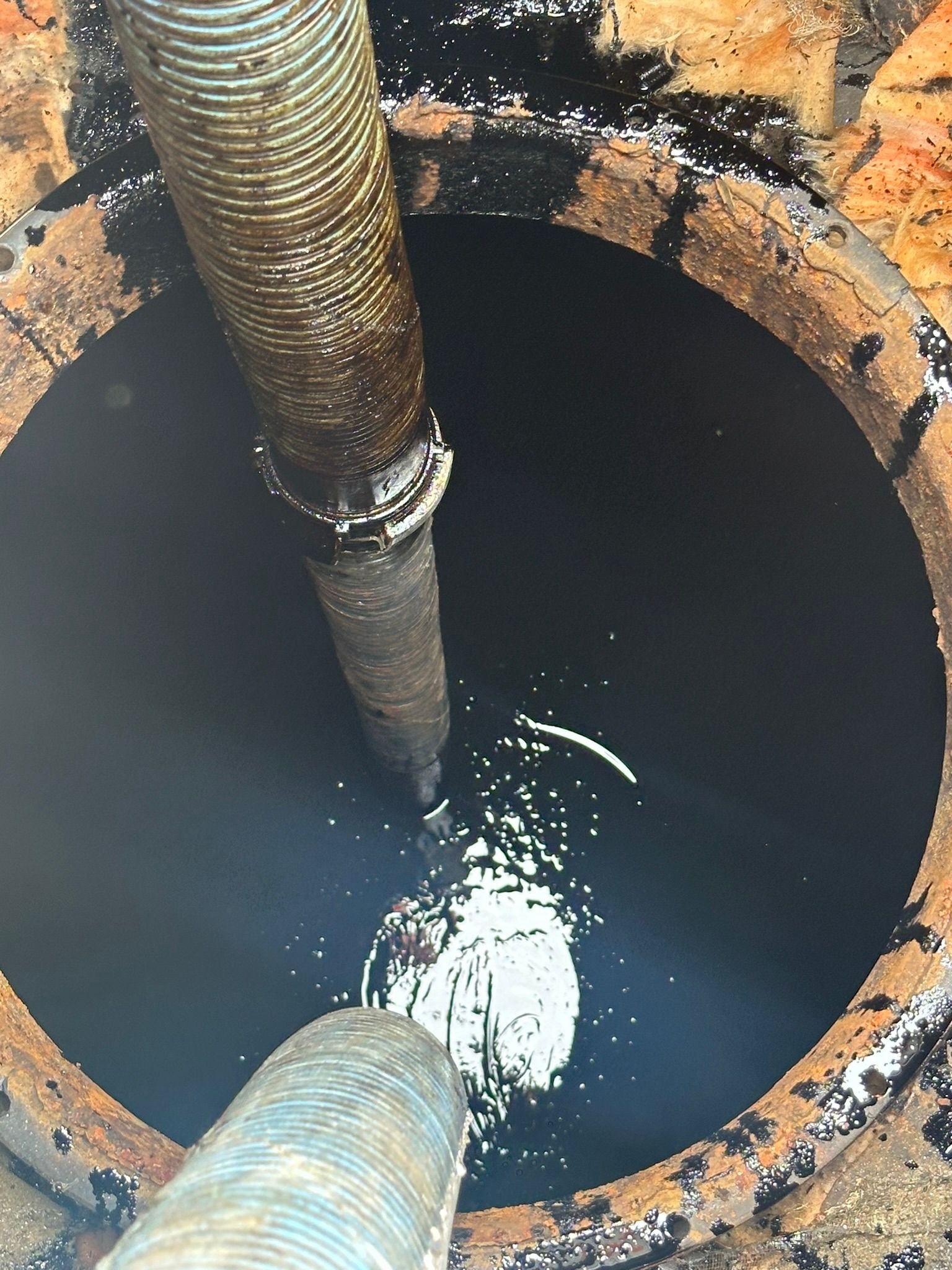 Flexible d'aspiration plongé dans un ouvrage cylindrique encore chargé